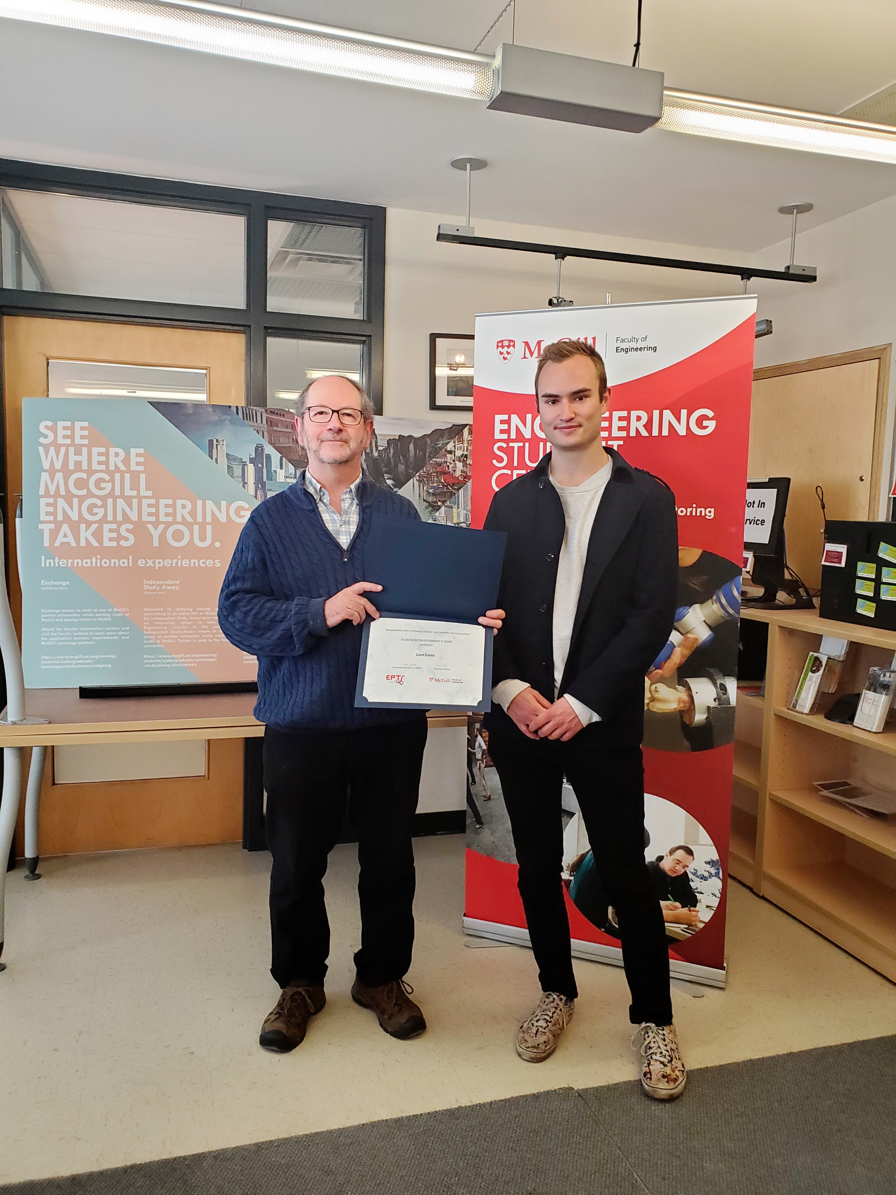2 man holding an award certificate