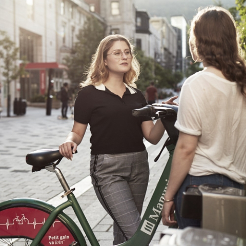 students on campus standing by a bike talking to each other