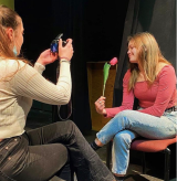An actress being photographed with a flower by another student