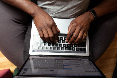 Hands typing on a laptop