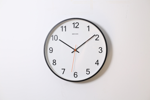 Black and white analog clock hanging on a wall