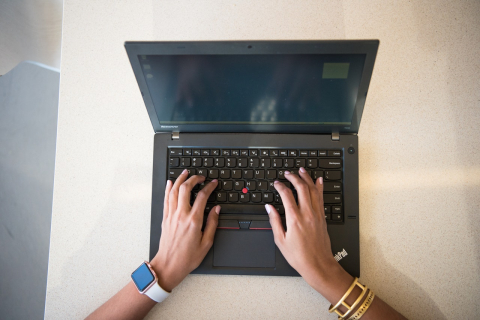 Hands typing on a laptop keyboard