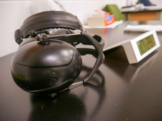 Earmuffs and digital clock laying on a desk at the entrance to the large exam room.
