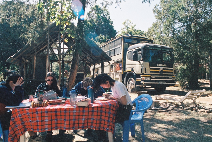 Students working on camping table with Bunduz truck at the back