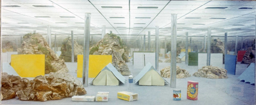 Andrea Branzi work with two tents at the center in a large hall, surrounded by packaging and titled "Non-Stop City"