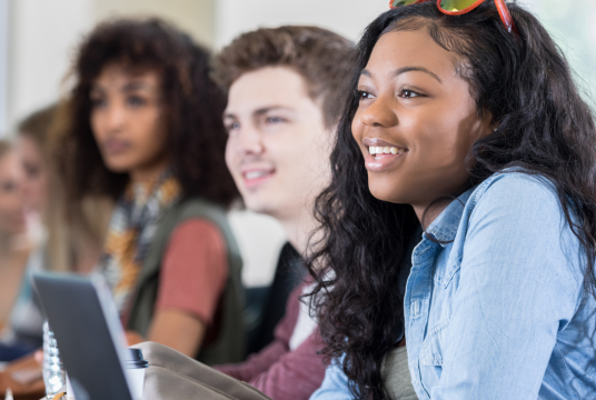 A group of students seated and listening to someone