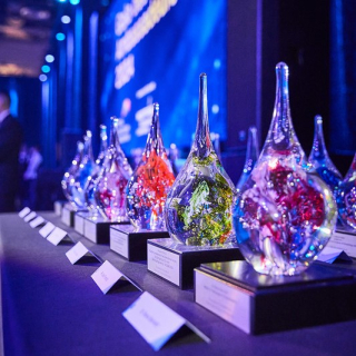 man holding glass globe award