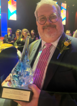 man holding glass globe award