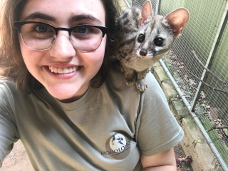 Oceanna, former McGill student studying veterinary medicine poses with a genet at a wildlife rehabilitation centre in South Africa