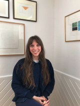 student smiling white background with hanging frames