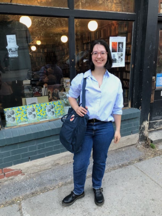 Julie Jacques in front of The Word bookstore, in anticipation of a poetry book launch for Pierre Nepveu’s The Four-Doored House and Anita Lahey’s While Supplies Last in May 2023. 