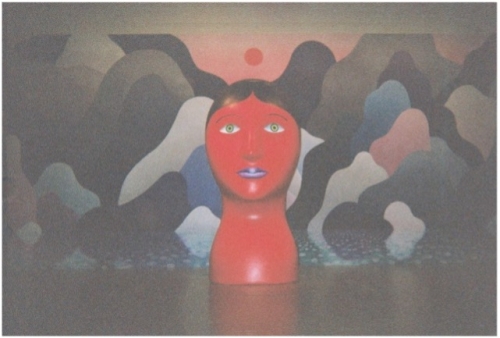  Photo of Nicolas Party’s sculpture titled “Head” in front of an abstract mural also painted by Party (Image by Chantay)