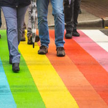 people from diverse conditions are walking on a rainbow colored zebra cross
