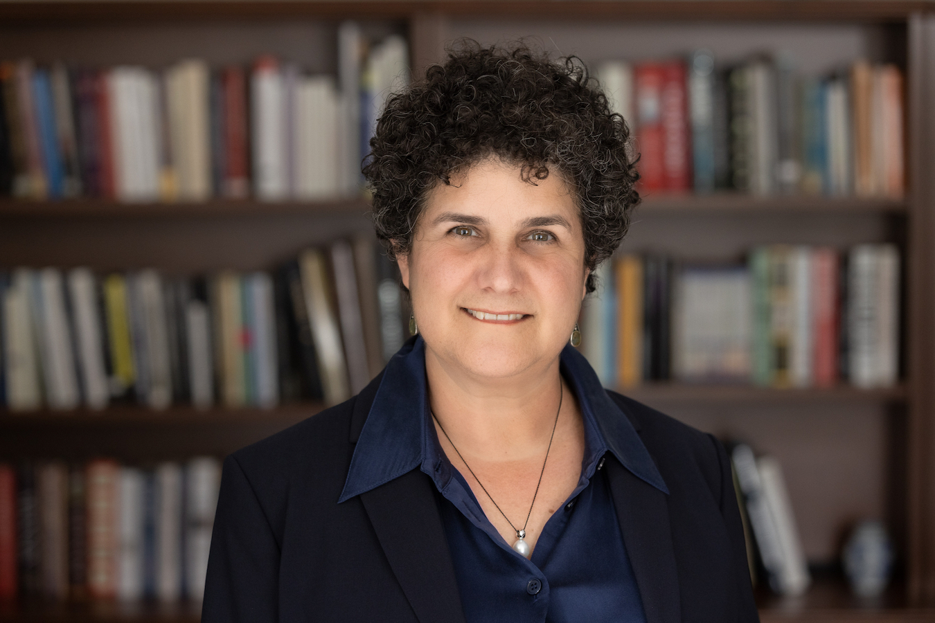 Headshot of person with bookshelf background 