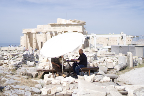 two people sitting at a table among ruins