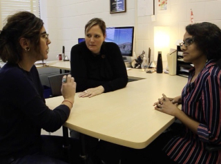 Dr. Francesca Capozzi (left), Dr. Jelena Ristic (middle), and Dr. Effie Pereira (right) sitting around a desk and talking. 