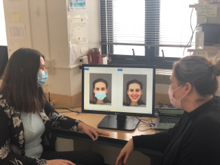 Two women looking at a screen wearing face masks