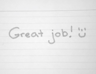A sticky note with the words "Great Job!" on it and a smiley face