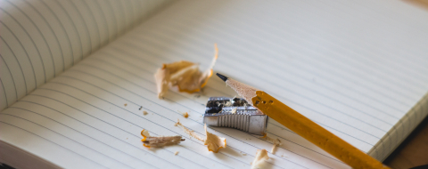a pencil with sharpener and shavings on a notebook
