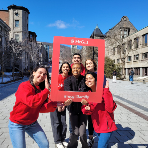 Group of students outside holding McGill Family frame