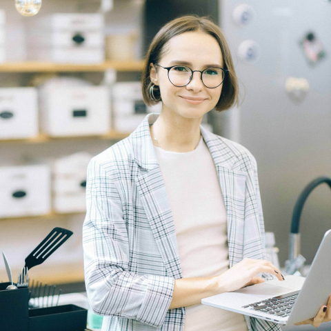 Woman standing with laptop. 