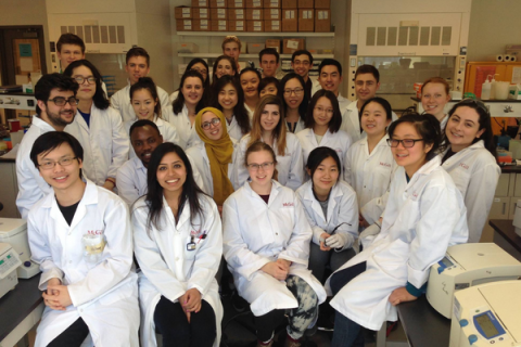 Biochemistry students pose for a photo in white lab coats