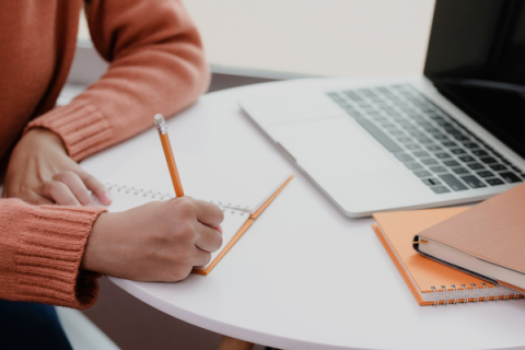 Person filling out a document on a desk