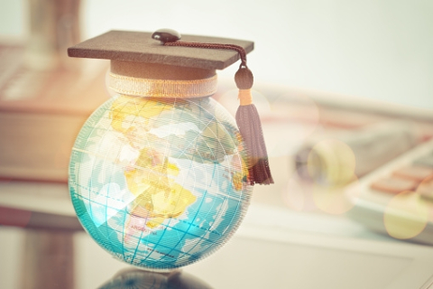 A world globe with a graduation cap on.