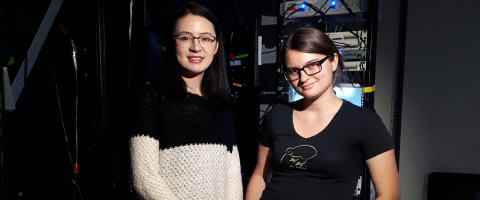 two students standing in a research room