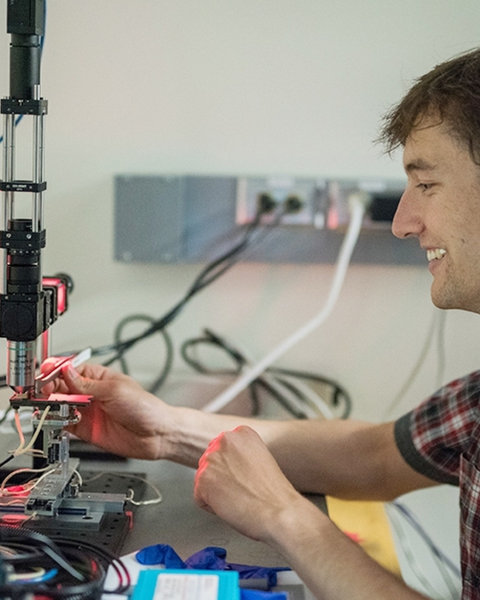 Student manipulating a microscope