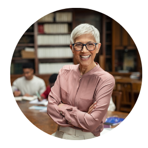 female professor in front of a desk with two students working behind it