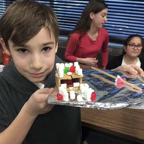 Young student with gingerbread house 