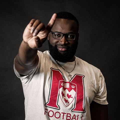 Black student wearing a McGill Football t-shirt