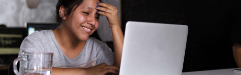 student looking at her laptop and smiling