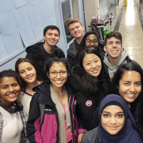 a group of high school students standing in the school hallway and smiling