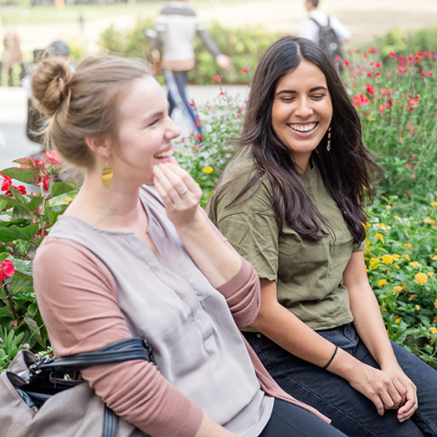 two female students smiling on campus 