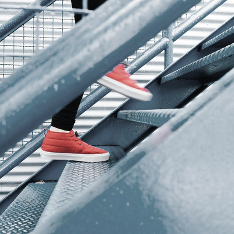 person climbing up the stairs wearing red shoes