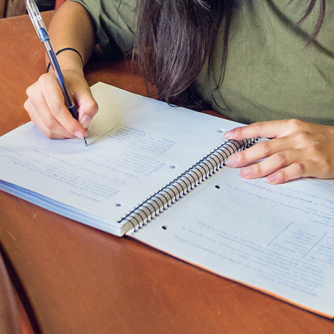 close up image of student writing on a notebook