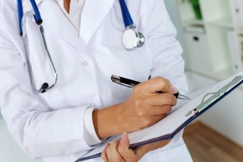 person writing notes in hospital setting