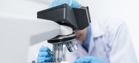 Person looking into microscope in lab