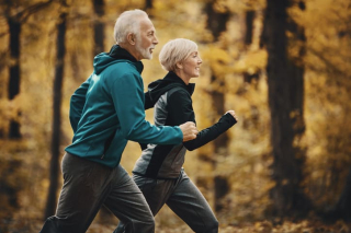 An older man and woman running side by side and smiling
