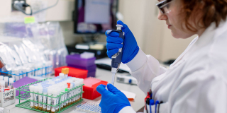 woman in the lab doing an experiment with a pipette