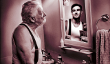 an old man looking in the mirror and seeing a young man