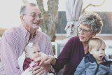 a grandma and grandpa holding two children