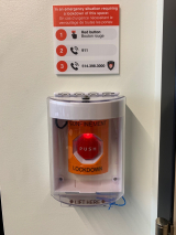 The lockdown button looks like a pull fire alarm station except the casing is white and the red button is pushed which sits in an orange housing. 