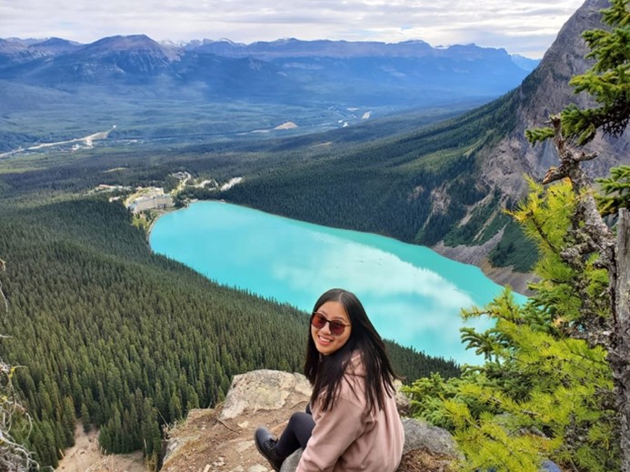 Yue is pictured in front of a large lake.