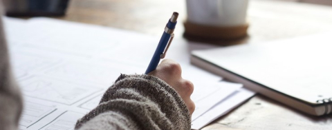 Close view of a person writing on a piece of paper