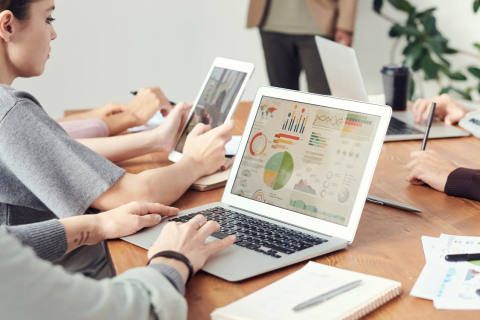 Multiple people on their laptops working with charts