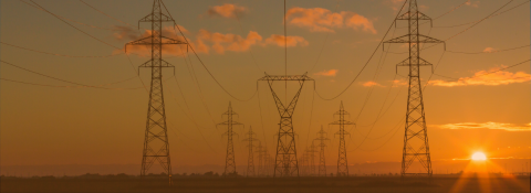 landscape with sunset in the background and many electricity towers 