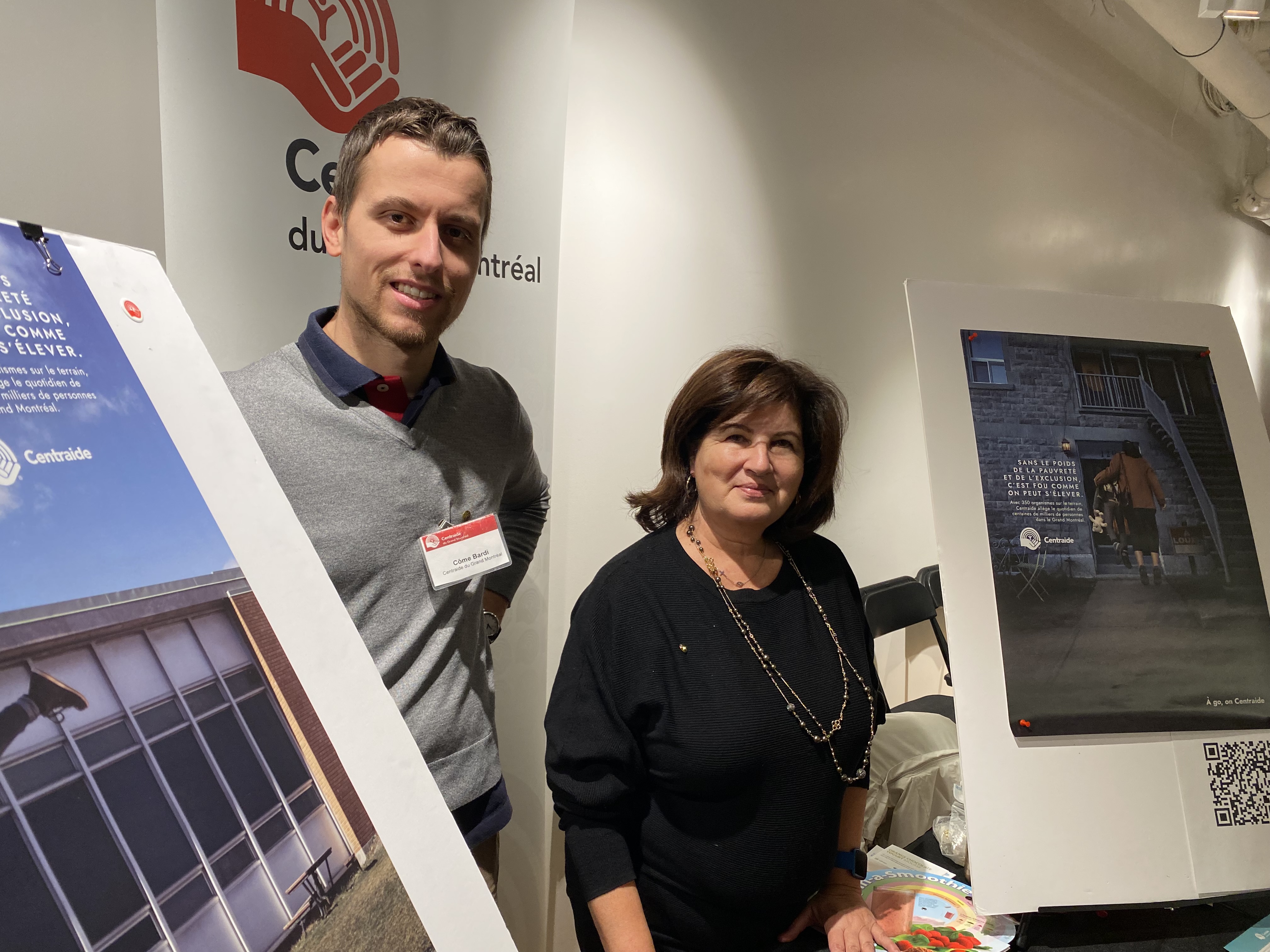 McGill Centraide Committee member, Christine Chahade and Centraide Rep Côme Bardi standing at the Centraide booth at the McGill Health Fair surrounded by posters and